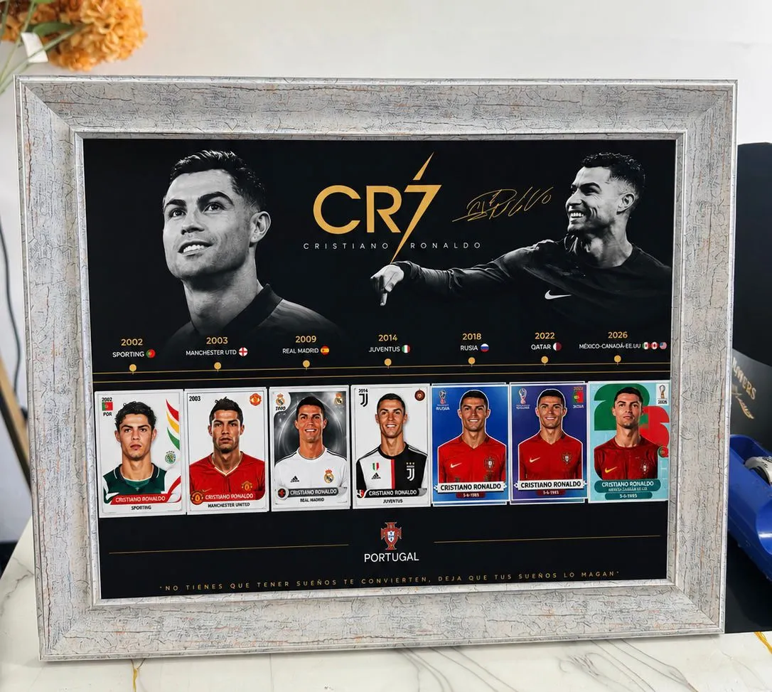 Cuadro con marco claro y una lámina que recorre la trayectoria de un futbolista, con cromos de sus equipos y una frase al pie.